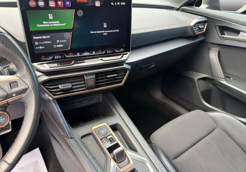 Intérieur avant droit de la CUPRA Formentor 2025, tableau de bord noir avec écran tactile central et volant cuir perforé.