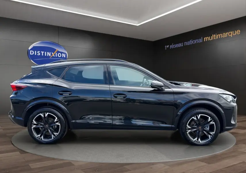Vue latérale droite d'un CUPRA Formentor noir brillant avec jantes alliage distinctives en showroom.