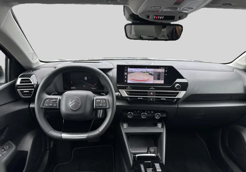 Vue frontale de l'habitacle noir du Citroën C4 X 1.2 hybride 2025 avec écran tactile et volant multifonction.