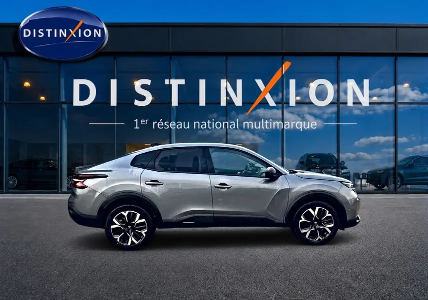 Profil côté gauche d'une Citroën C4 X gris mercure 2025, avec jantes alu et vitres arrière surteintées.