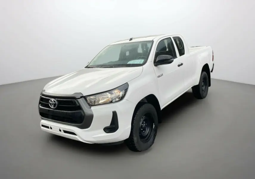 Toyota Hilux 4x4 blanc pur en 3/4 avant droit, avec calandre noire et jantes acier noires visibles.