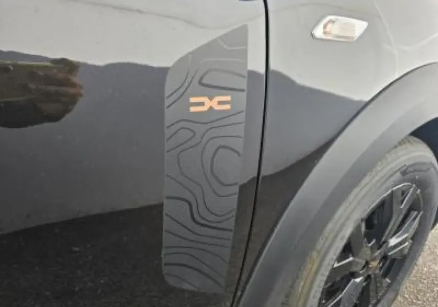 Détail du sticker topographique noir et orange sur la porte côté gauche d'une Dacia Sandero Stepway noir nacré.