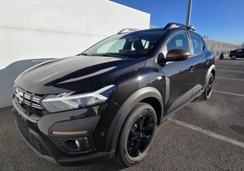 Dacia Sandero III Stepway noir nacré en 3/4 avant droit avec barres de toit brun cuirvré et jantes noires.