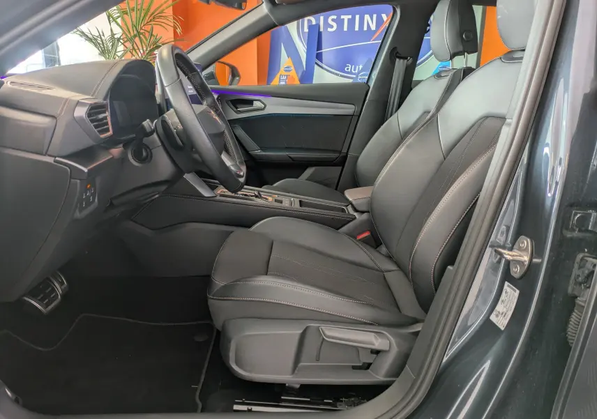 Vue intérieure côté conducteur de la CUPRA Formentor gris magnétique 2025, sièges sport en tissu et similicuir avec surpiqûres contrastées.