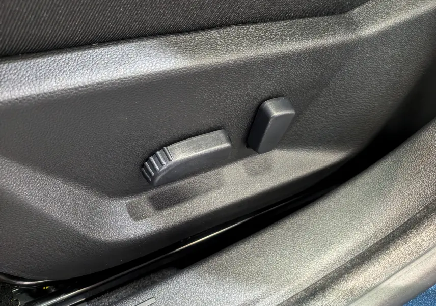 Gros plan sur les commandes de réglage électrique du siège conducteur du Dacia Bigster 2026, intérieur noir.