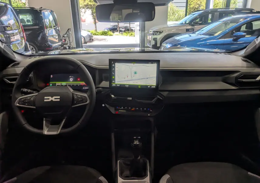 Vue intérieure frontale du tableau de bord du Dacia Bigster 2026 avec écran tactile central et volant multifonction.