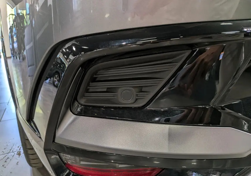 Gros plan sur le pare-chocs arrière gris schiste du Renault Rafale 2026, mettant en valeur un capteur de stationnement noir.