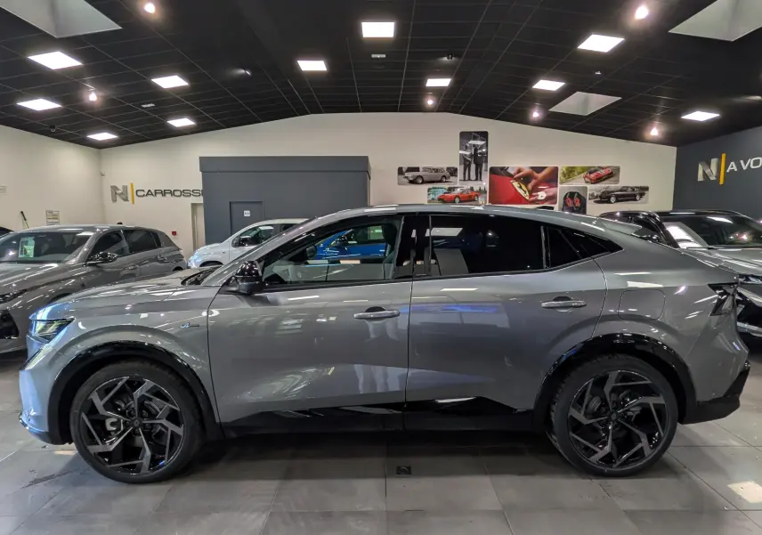 Vue de profil côté gauche d'un Renault Rafale gris schiste avec jantes noires en showroom.