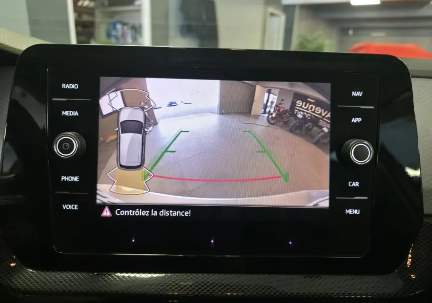 Écran central affichant la caméra de recul du Volkswagen T-Cross gris, vue arrière avec guidage de trajectoire.