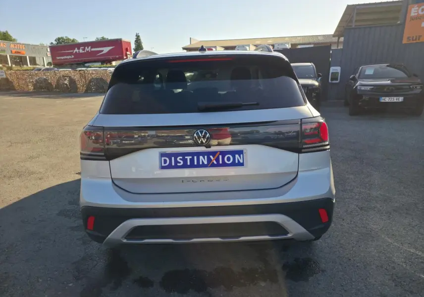 Vue arrière d’un Volkswagen T-Cross gris métallisé 2025 avec feux arrière LED et logo VW centré.