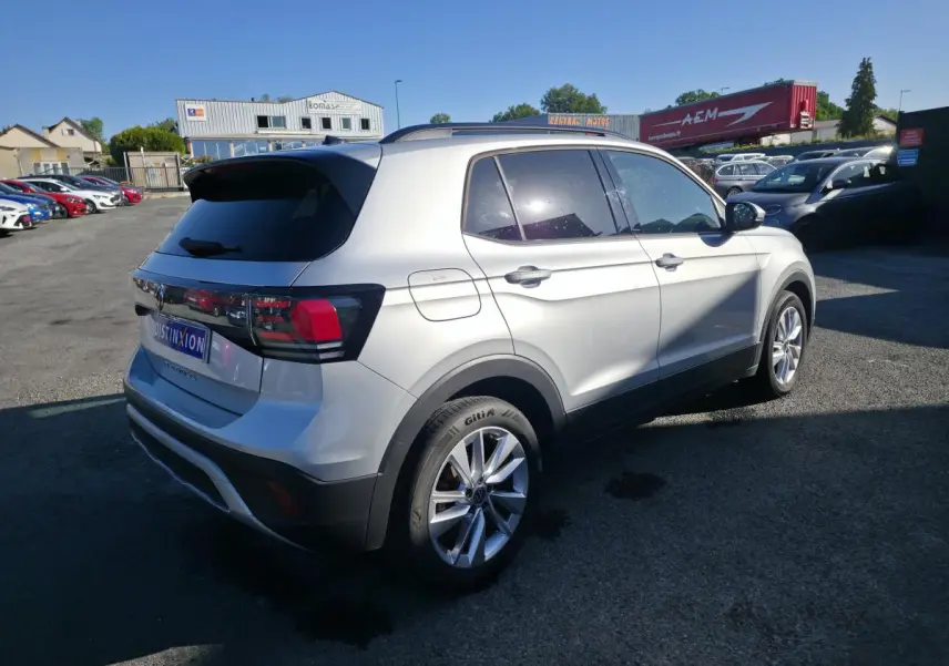 Volkswagen T-Cross gris métallisé vu en 3/4 arrière droit, avec jantes alliage 17 pouces et vitres teintées.