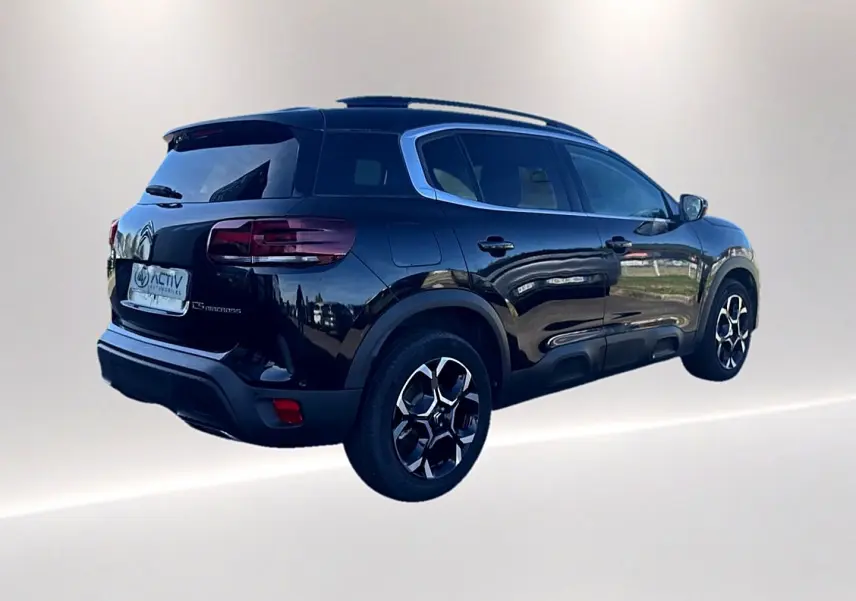 Vue 3/4 arrière droite du Citroën C5 Aircross noir avec barres de toit et jantes alu distinctives.