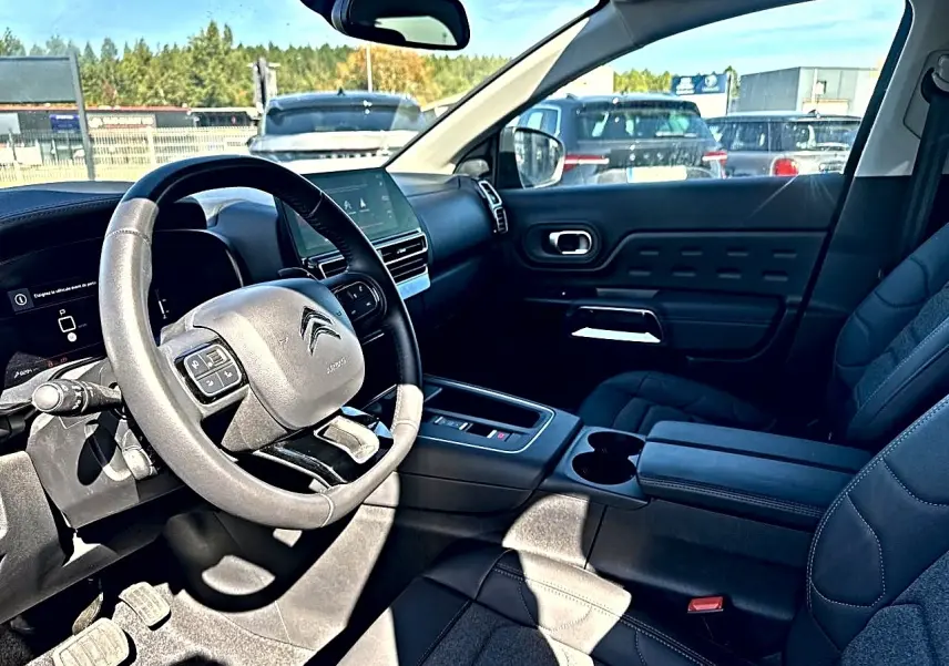 Vue intérieure côté conducteur du Citroën C5 Aircross noir 2025, volant cuir multifonction et écran tactile central visible.