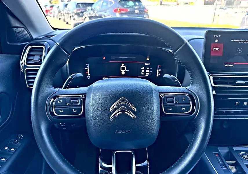Vue intérieure centrée sur le volant cuir noir multifonction du Citroën C5 Aircross 2025 avec tableau de bord numérique.