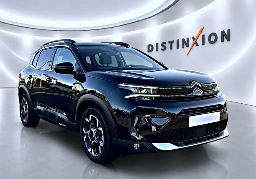 Citroën C5 Aircross noir vue 3/4 avant droit avec barres de toit et jantes alu distinctives.