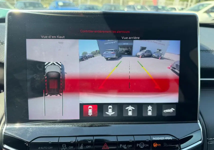 Écran tactile intérieur montrant la caméra de recul et vue en hauteur du Jeep Compass blanc 2025 en stationnement.