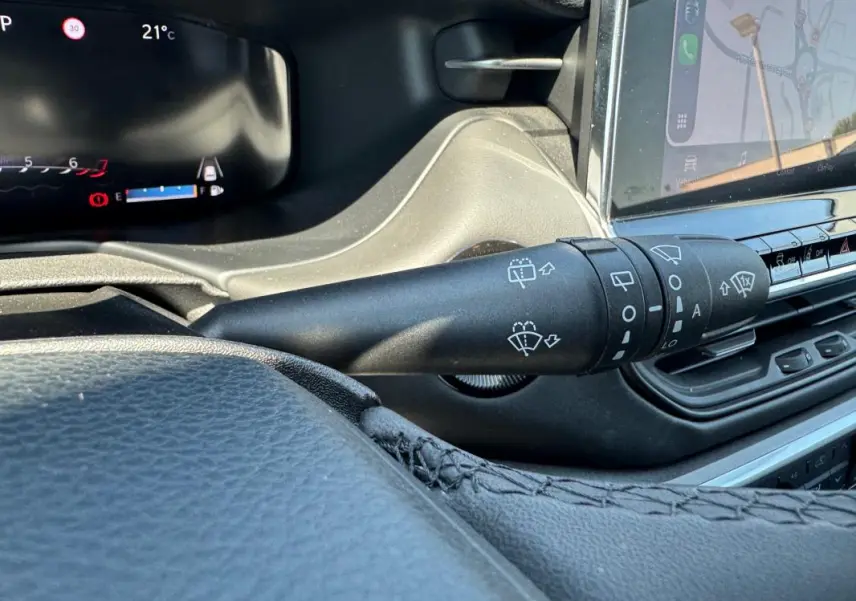 Gros plan sur la commande des essuie-glaces du Jeep Compass 2025, intérieur noir avec écran tactile visible.