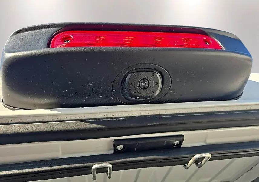 Gros plan sur la caméra de recul et le feu stop rouge du hayon arrière du Peugeot Boxer Fourgon blanc.