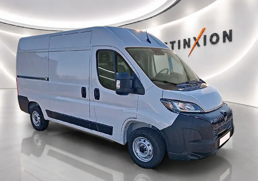 Vue 3/4 avant droit d’un Peugeot Boxer Fourgon blanc avec porte latérale coulissante et pare-chocs noir.