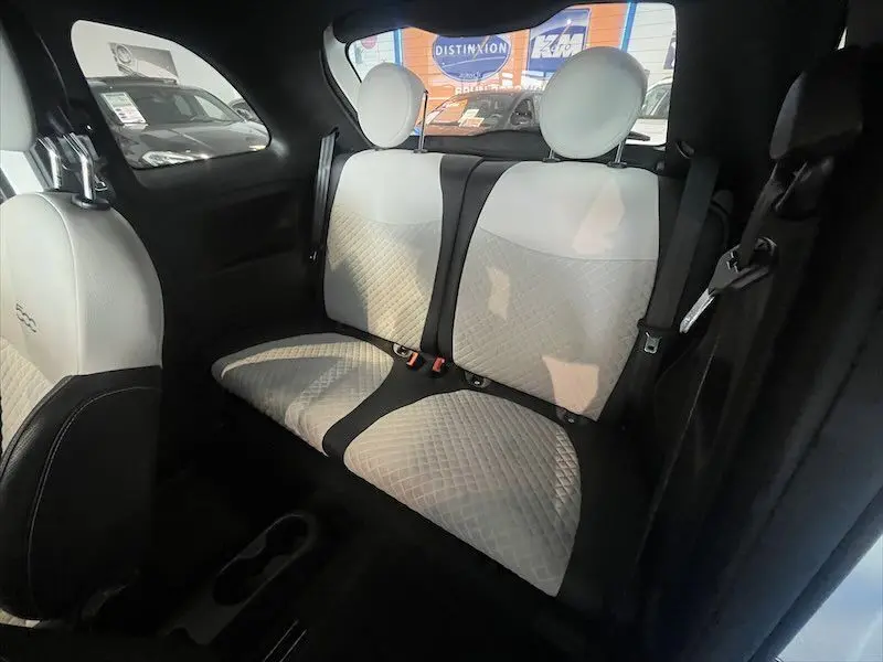 Vue intérieure arrière de la Fiat 500 blanche 2021, sièges bicolores noir et blanc avec surpiqûres en losange.