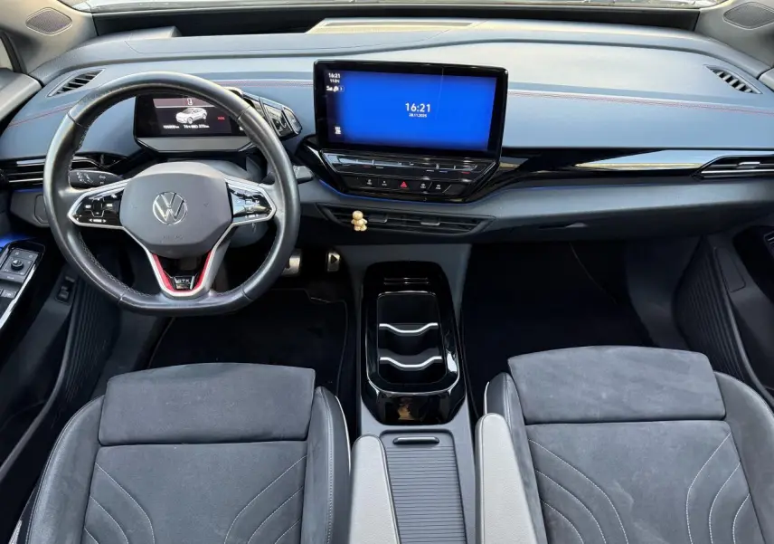 Vue intérieure avant du Volkswagen ID.4 GTX 2021, tableau de bord moderne avec écran tactile et sièges en ArtVelours gris.