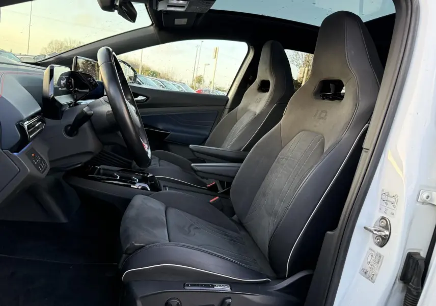Intérieur côté conducteur d'un Volkswagen ID.4 GTX blanc, sièges sport en ArtVelours bi-colore avec toit panoramique en verre.