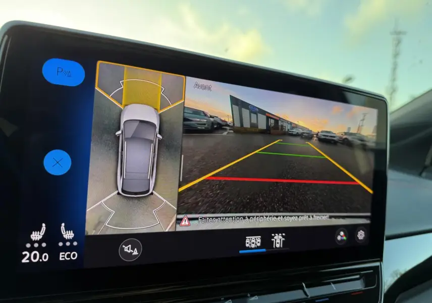 Écran intérieur du Volkswagen ID.4 GTX blanc montrant la caméra 360° et l'affichage de la vue avant en stationnement.