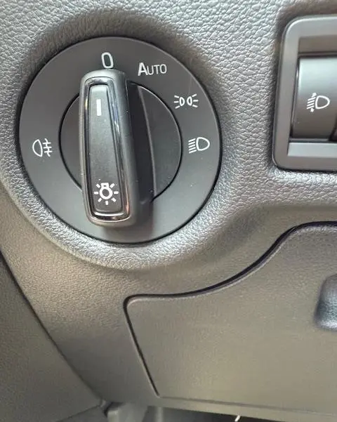 Gros plan sur la molette de commande des phares du Skoda Kamiq 2024, finition Ambition, avec réglage automatique visible.