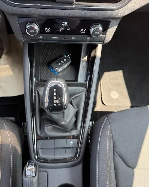 Vue plongeante sur la console centrale noire du Skoda Kamiq 2024, avec levier de vitesse automatique et clé posée.