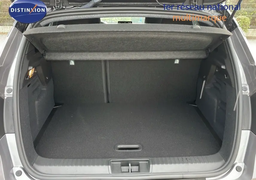 Coffre ouvert vu de l'arrière du Renault Captur gris Cassiopée métal avec toit noir, montrant un espace de chargement vide.