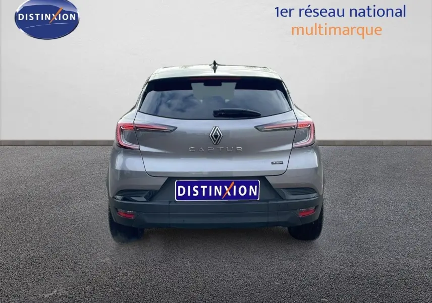 Vue arrière d'un Renault Captur gris Cassiopée métal avec toit noir, affichant le logo et le modèle clairement visibles.