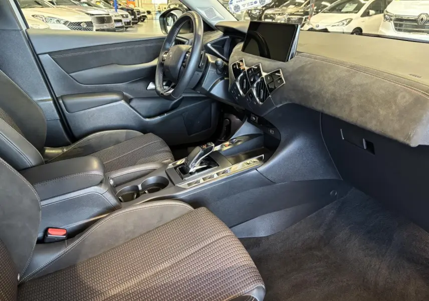 Intérieur avant droit du DS3 Crossback 2024, avec sellerie noire, tableau de bord en Alcantara et console centrale brillante.