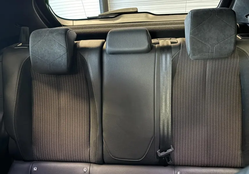 Vue rapprochée des sièges arrière en tissu et cuir noir du DS3 Crossback 2024, avec appuie-têtes et ceinture de sécurité.