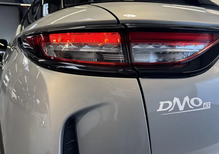 Gros plan sur le feu arrière droit du DS3 Crossback 2024 en Crystal Pearl, soulignant les détails lumineux et la carrosserie nacrée.