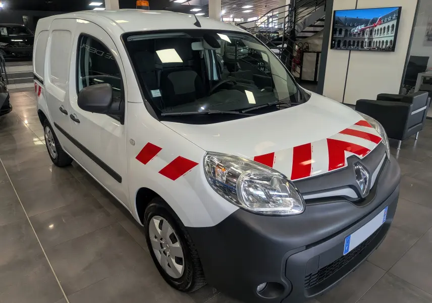 Renault Kangoo Express blanc minéral en vue 3/4 avant droit avec bandes rouges diagonales sur le capot et l'aile.