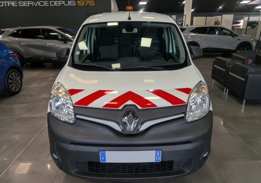 Vue frontale du Renault Kangoo Express blanc minéral avec bandes rouges diagonales et gyrophare orange au toit.