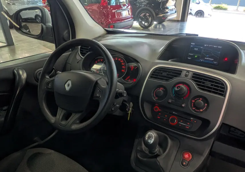 Vue intérieure côté conducteur du Renault Kangoo Express blanc, montrant le volant, tableau de bord et écran R-Link.