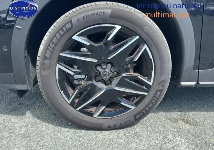 Gros plan sur la roue avant droite noire d’un Peugeot 5008 Hybrid 145 allure e-dcs6 avec jante alu stylisée.