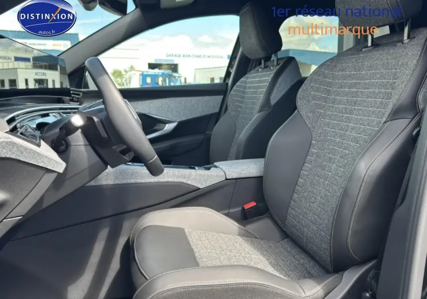 Vue intérieure côté conducteur du Peugeot 5008 Hybrid 145 allure e-dcs6 2025, sièges tissu gris et cuir noir.