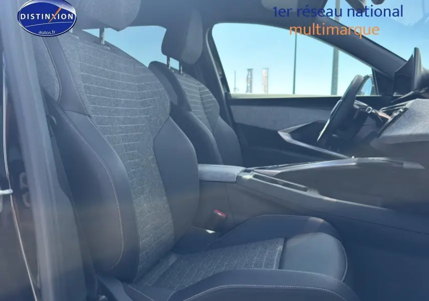 Vue intérieure côté gauche du Peugeot 5008 Hybrid 145 allure 2025, sièges tissu gris et cuir noir avec accoudoir central.
