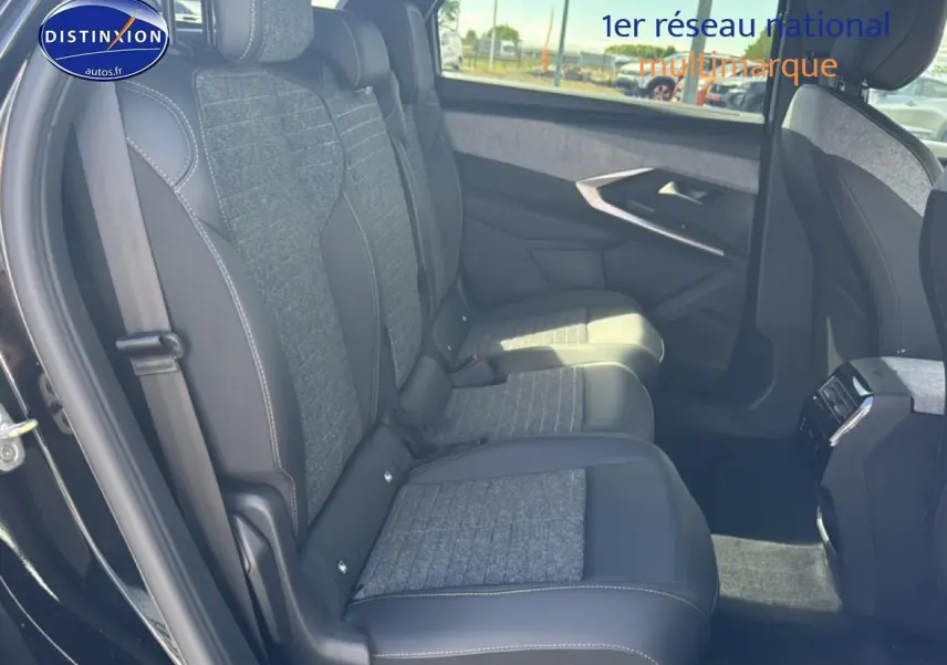 Vue latérale intérieure côté gauche montrant les sièges arrière en tissu gris et cuir noir du Peugeot 5008 Hybrid 145 allure 2025.