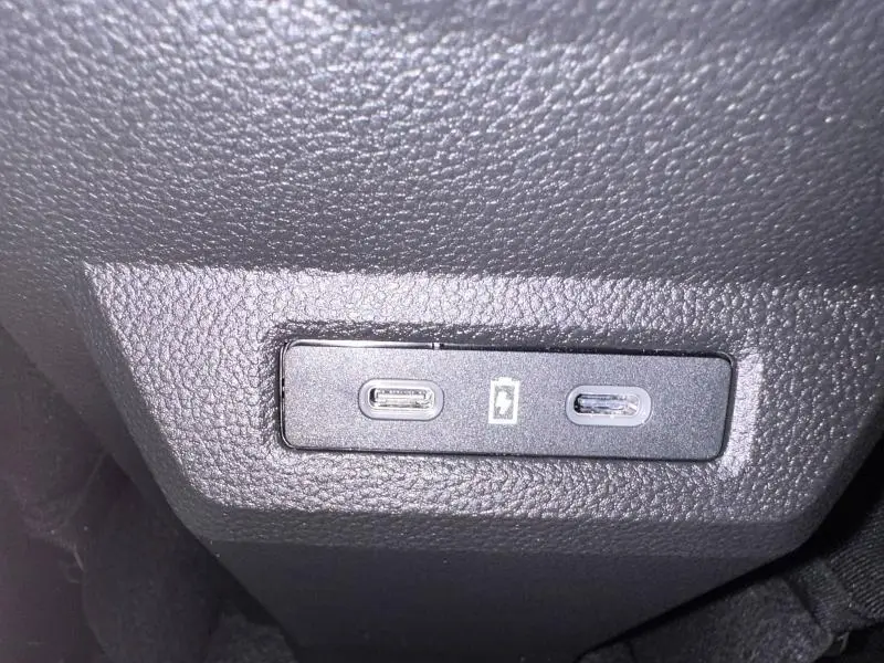 Prise USB double en gros plan sur la console intérieure d'un Dacia Duster 1.8 hybrid 155ch Journey 2025 noir nacré métallisé.