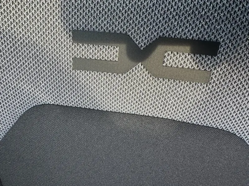 Détail du tissu de siège avec logo DACIA en relief sur fond gris et noir, intérieur du Dacia Duster 2025.