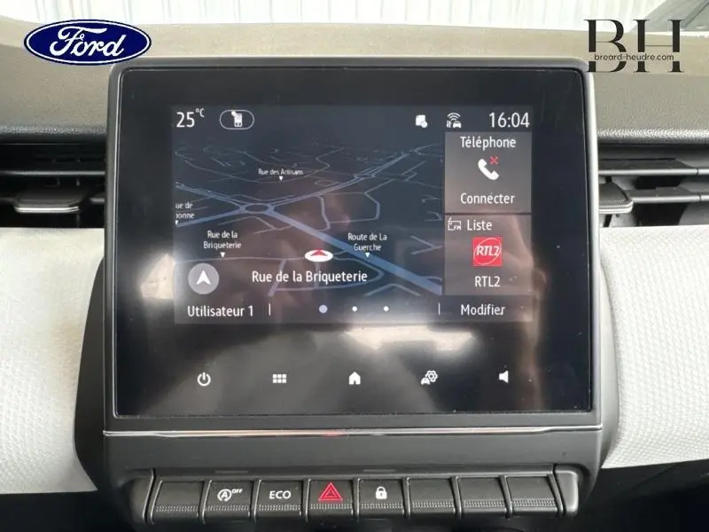 Écran tactile central avec GPS affichant une carte, dans une Renault Clio blanche vue de face intérieure.