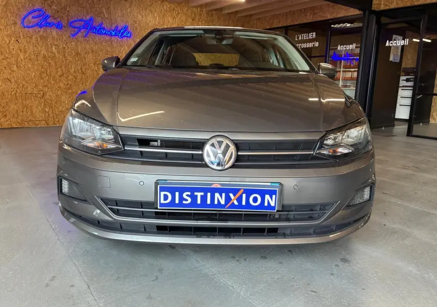 Vue avant d'une Volkswagen Polo gris métallisé 2018, mettant en valeur la calandre et les phares modernes.