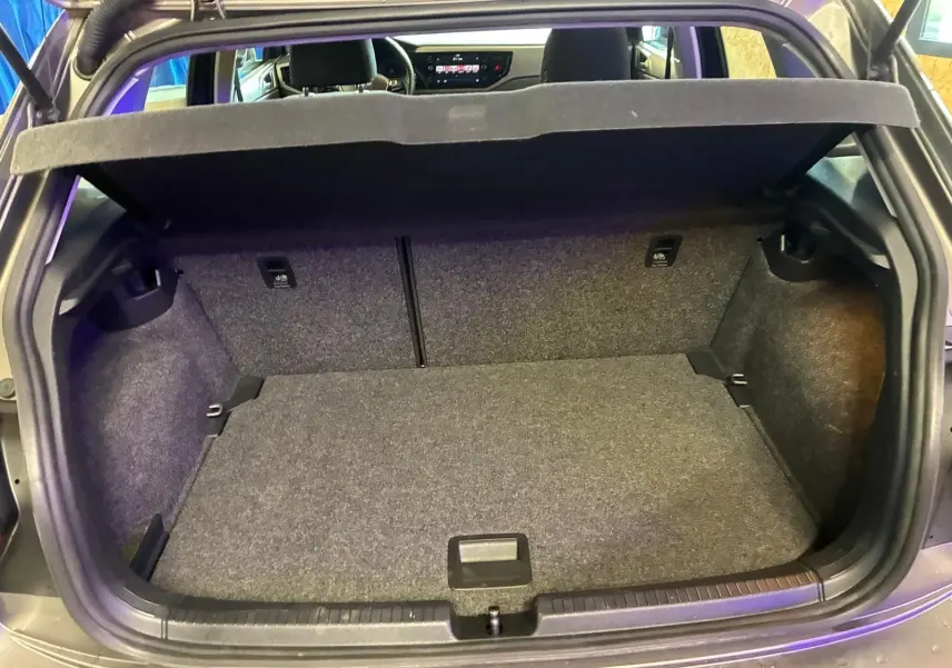 Coffre ouvert vu de l'arrière d'une Volkswagen Polo gris 2018, montrant l'espace de chargement et la tablette arrière relevée.