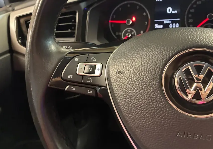 Gros plan sur le volant noir de la Volkswagen Polo 2018 avec commandes intégrées et tableau de bord en arrière-plan.