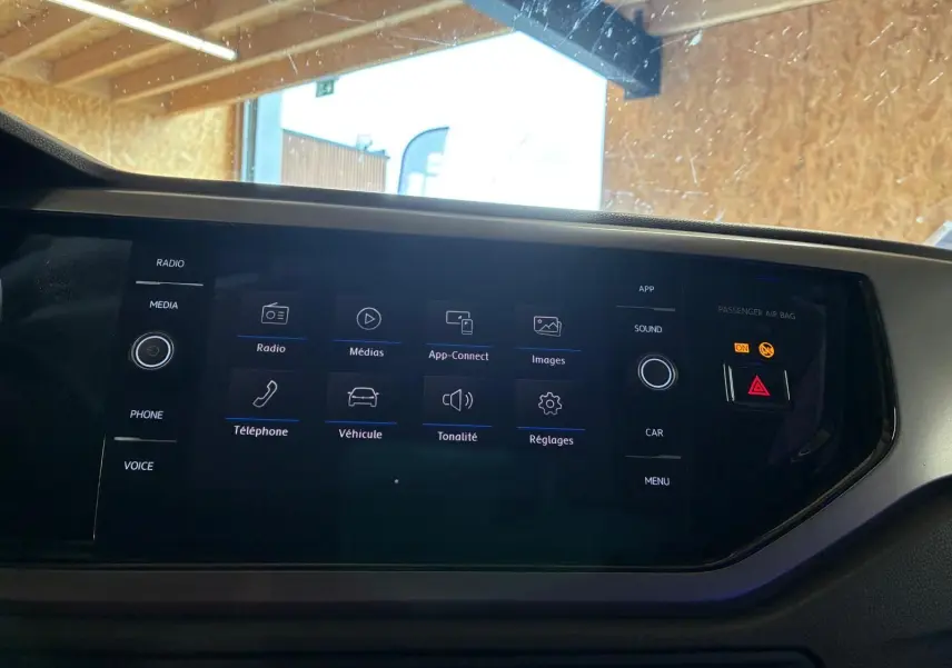 Écran tactile central du tableau de bord de la Volkswagen Polo gris 2018, affichant le menu multimédia et réglages.