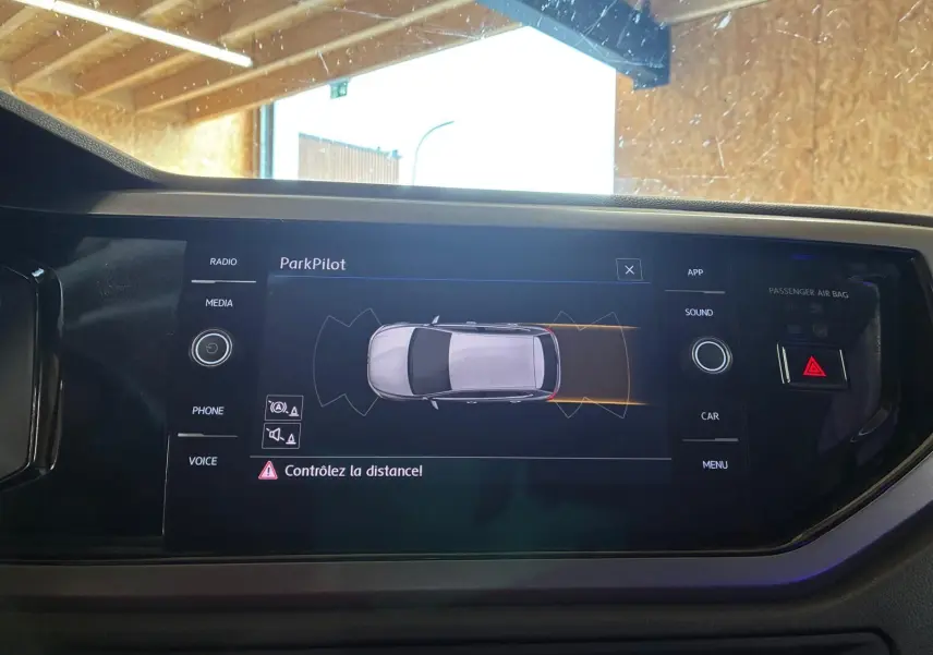 Écran central de la Volkswagen Polo gris 2018 montrant l'interface ParkPilot avec avertissement de distance.