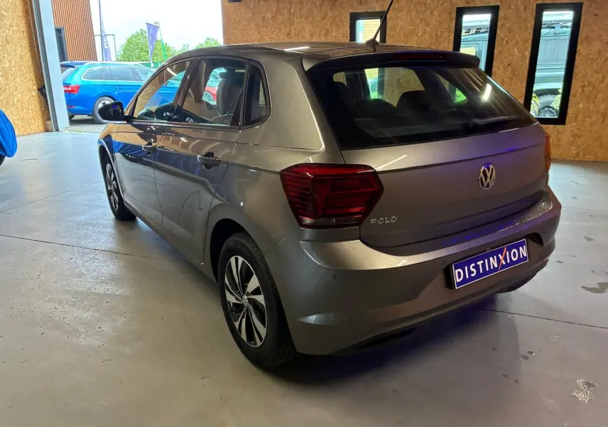 Vue 3/4 arrière droite d'une Volkswagen Polo gris métallisé 2018 avec hayon et jantes alliage distinctives.